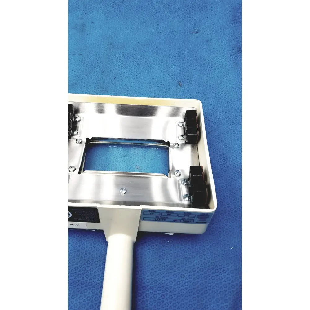 White plastic-handled burton ultraviolet examining light with metallic silver top plate and blue labeling for medical use