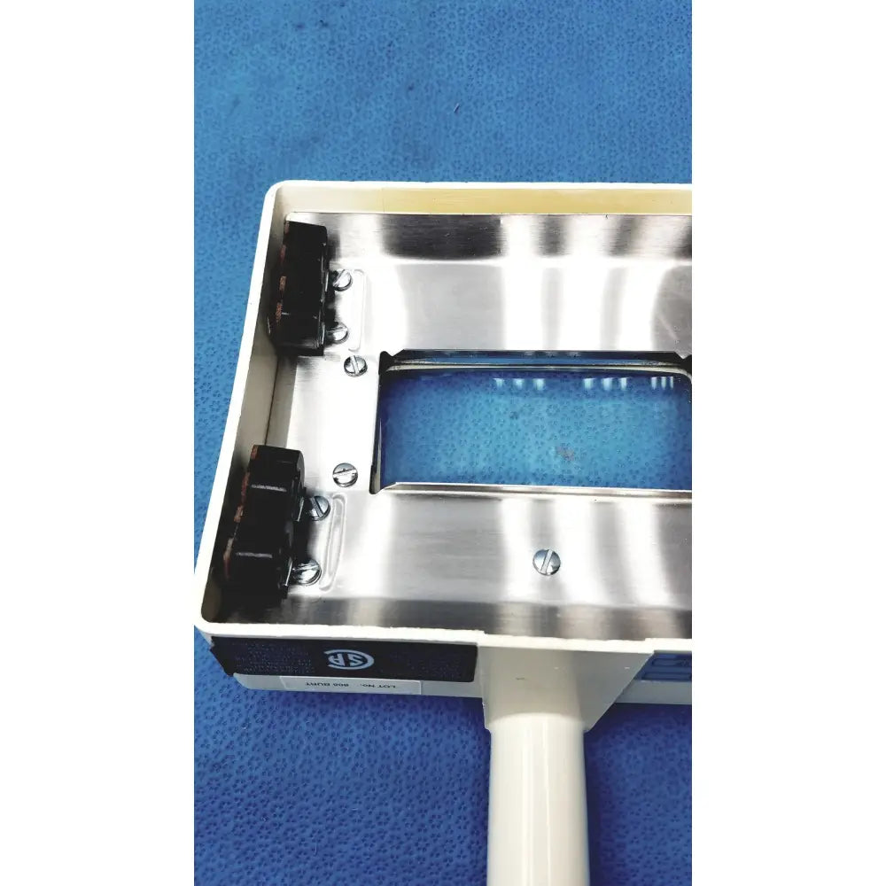 Silver metallic rectangular housing with black connectors and white handle of burton ultraviolet examining light 31601