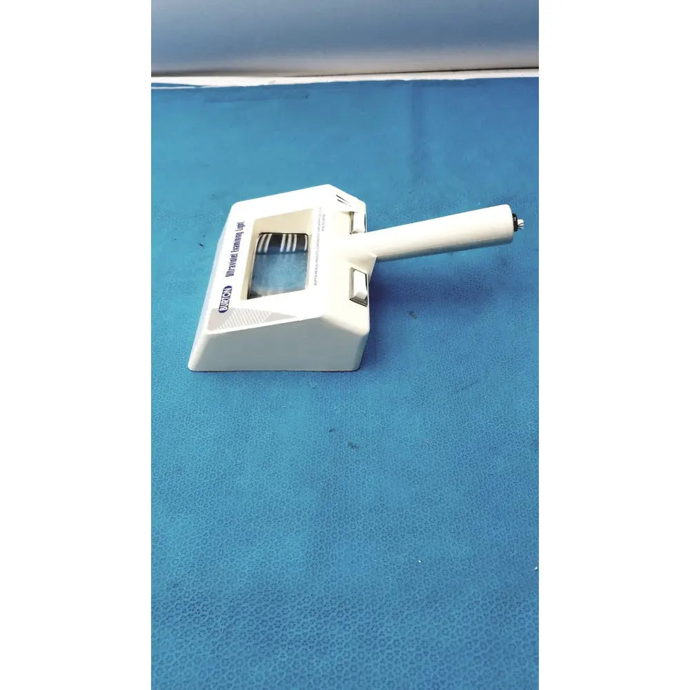 White plastic burton ultraviolet examining light with rectangular base handle and adjustable focus knob