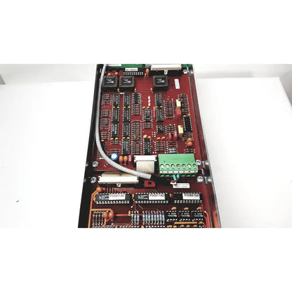 Red circuit board with black integrated circuits green terminal block and beige ribbon cable for bystronic amplifier cnc02 50a