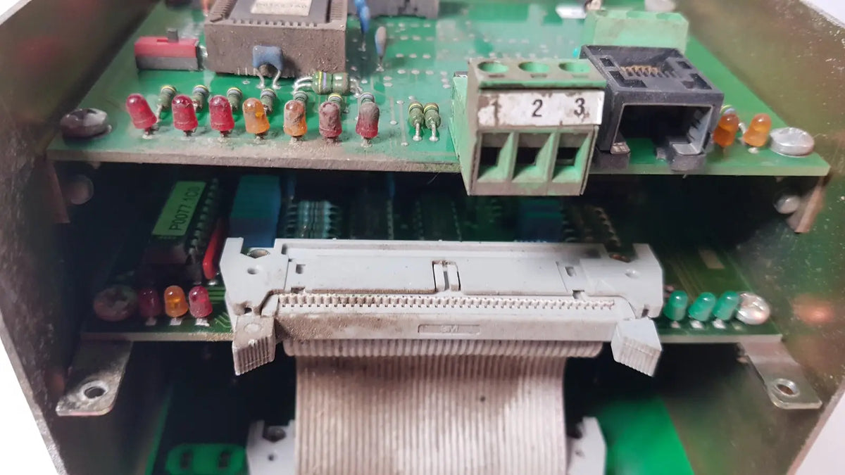 Gray plastic connector with ribbon cable on green circuit boards inside bystronic 702116-a amplifier enclosure