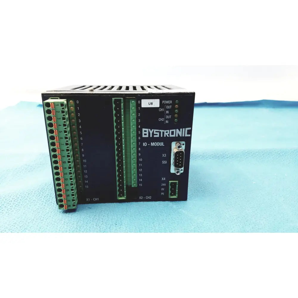 Black bystronic io-modul input output module with green terminal blocks and labeled ports for industrial control use