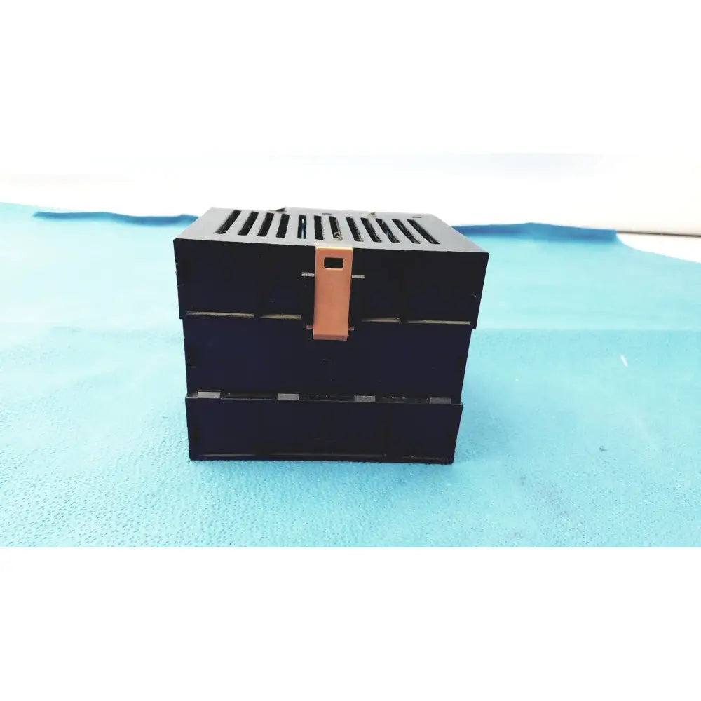 Black Bystronic modul input output box with copper-colored latch and horizontal slits on top for input output module use