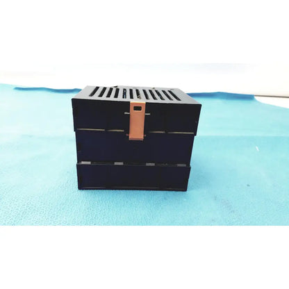 Black Bystronic modul input output box with copper-colored latch and horizontal slits on top for input output module use