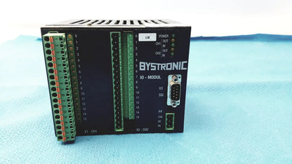 Black bystronic io-modul input output module with green terminal blocks and labeled ports for industrial control use