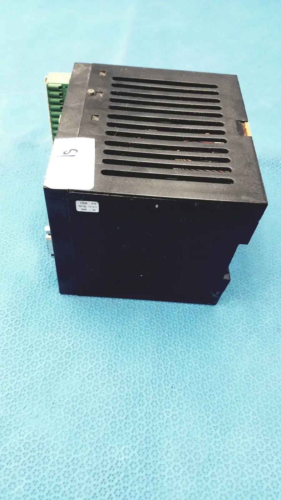 Black rectangular Bystronic modul input output unit with vented top and green terminal block on the side