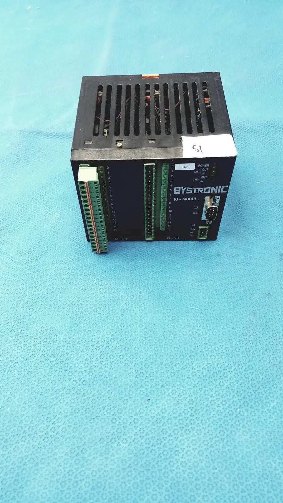 Black bystronic input output module with green terminal blocks and ventilation grille for industrial control applications