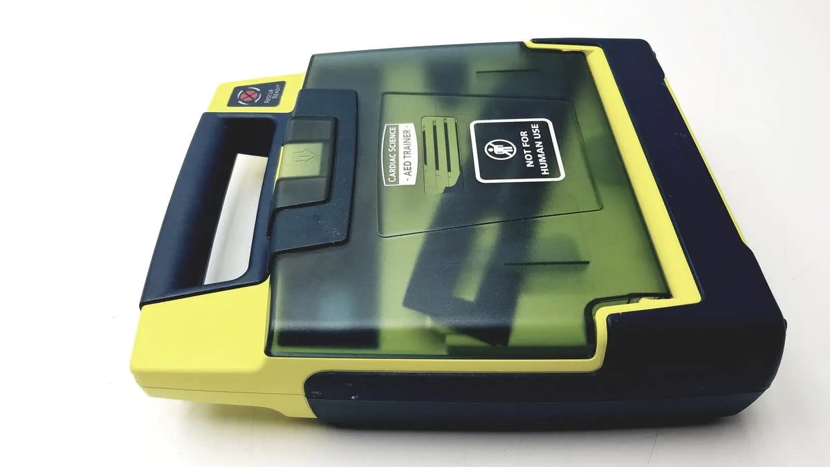 Yellow and black cardiac science aed trainer with transparent lid showing internal components for aed trainer teaching use