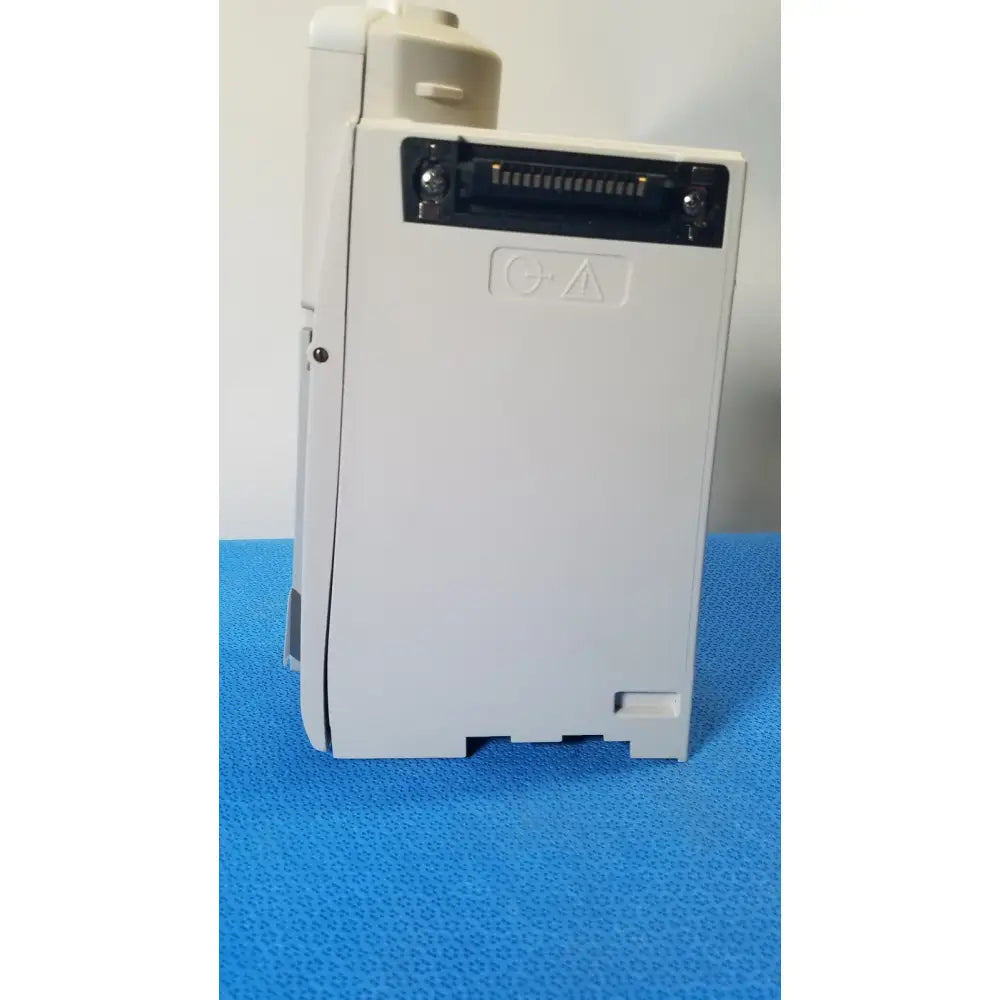 White plastic industrial control module with black connector port and safety symbol on the back of cardinal health alaris pump 8100 series