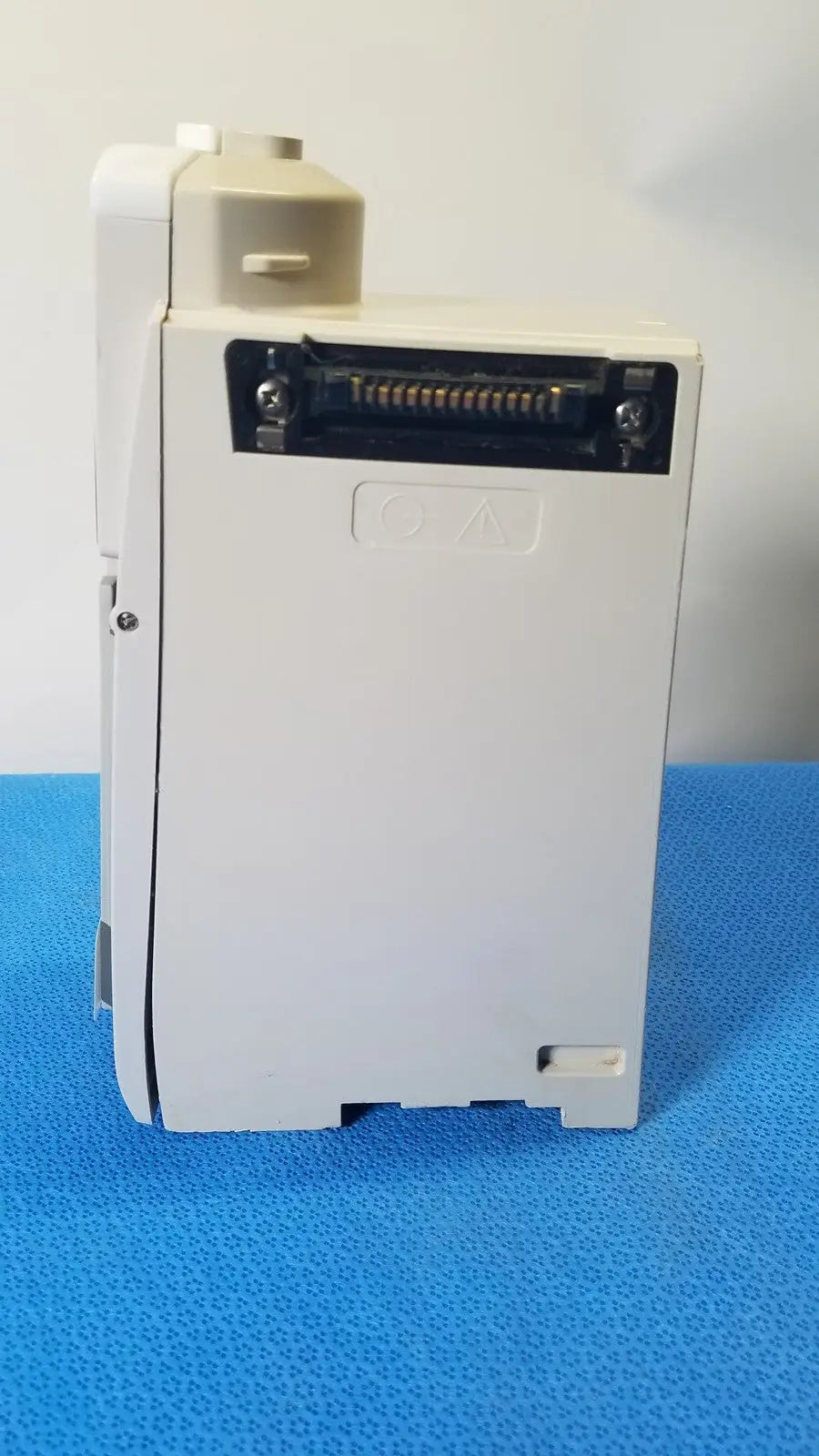 White plastic industrial control module with black connector port and embossed qa marking for cardinal health alaris pump 8100 series