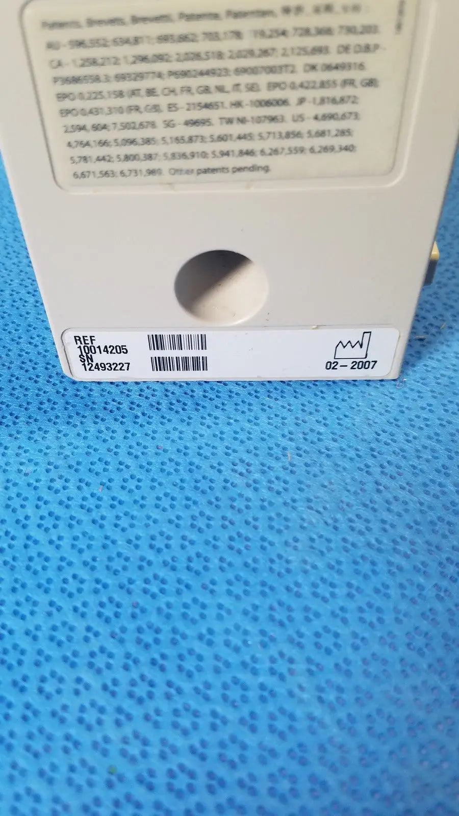 White plastic product label on the back of cardinal health alaris pump 8100 series with black text patent info and barcode