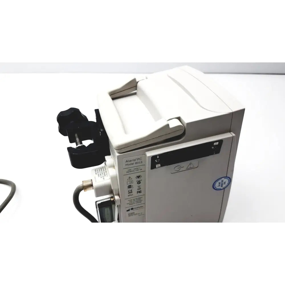 White cardinal health PC 8015 pump with guardrails suite MX featuring alarmspc model 0018 black clamp and control panel for reuse medical use