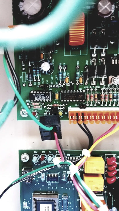 Green circuit board of the Cardkey s300-xl access control panel controller with electronic components and colored wires