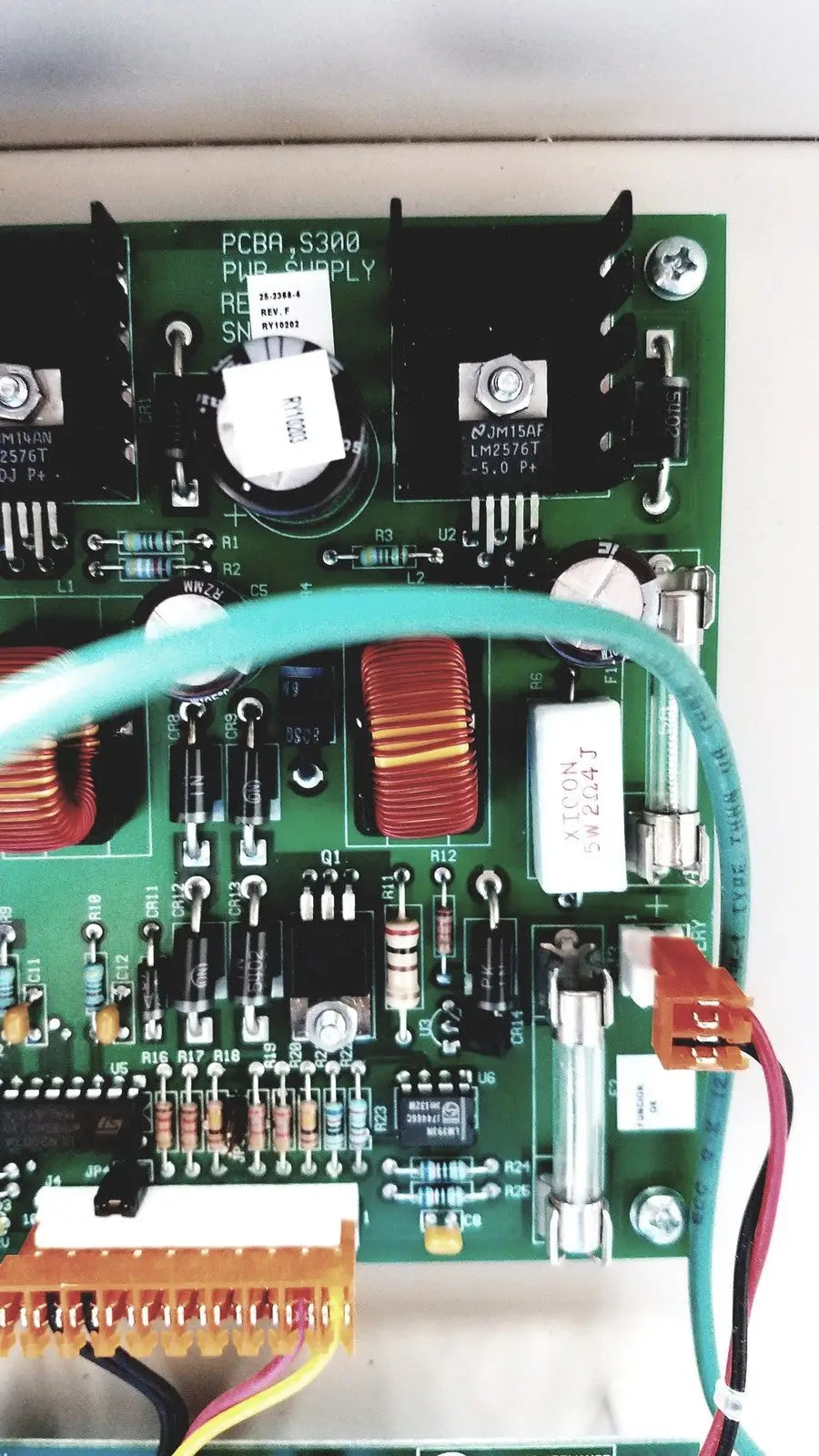Green pcb board with electronic components and teal cable of cardkey s300-xl access control panel controller