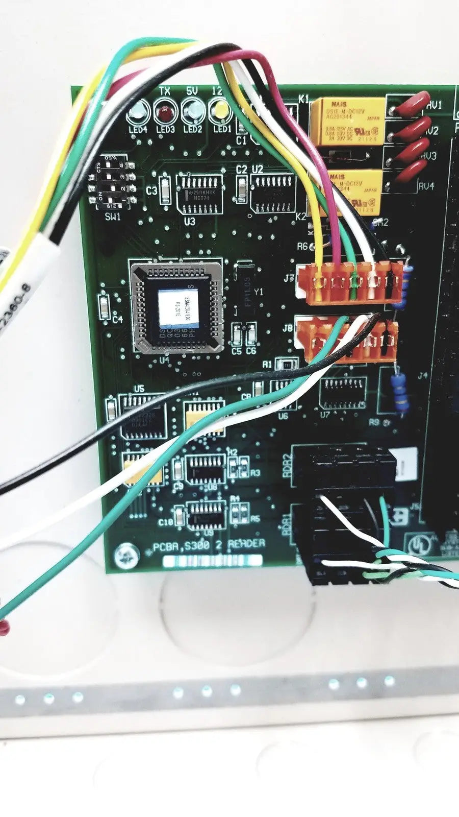 Green circuit board with labeled pcba_s360_2 reyder microprocessor and multicolored wires in s300-xl access control panel controller