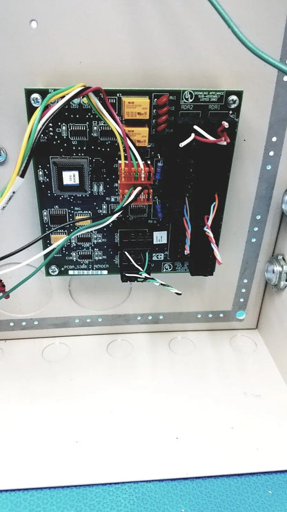 Black circuit board with electronic components and colored wires in the cardkey s300-xl access control panel controller