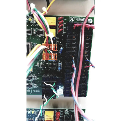 Green circuit board of cardkey s300-xl access control panel controller with red black switches yellow capacitors and wires