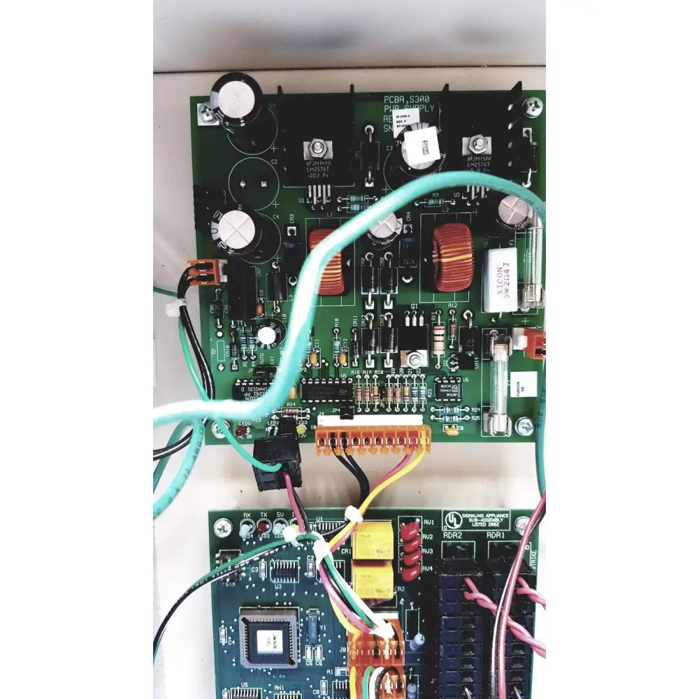 Green printed circuit board with electronic components and light blue cable in cardkey s300-xl access control panel controller