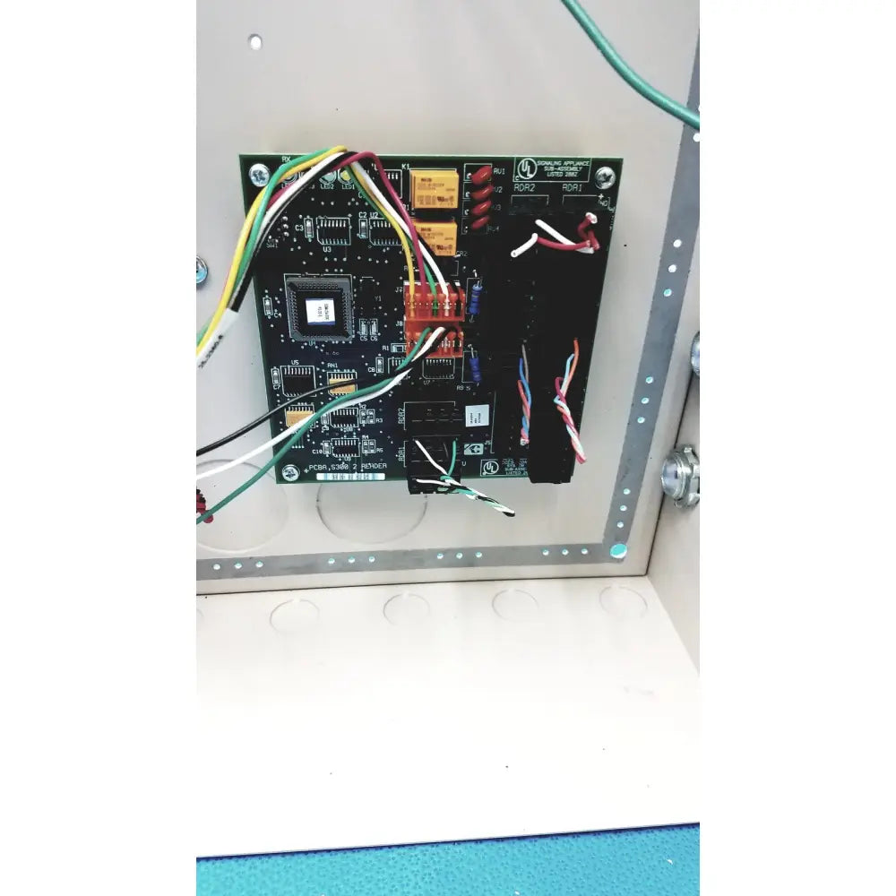 Black circuit board with electronic components and colored wires in the cardkey s300-xl access control panel controller