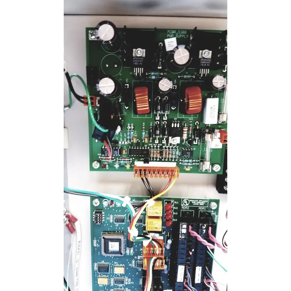 Green printed circuit board with white capacitors and red toroidal inductors for cardkey s300-xl access control panel controller