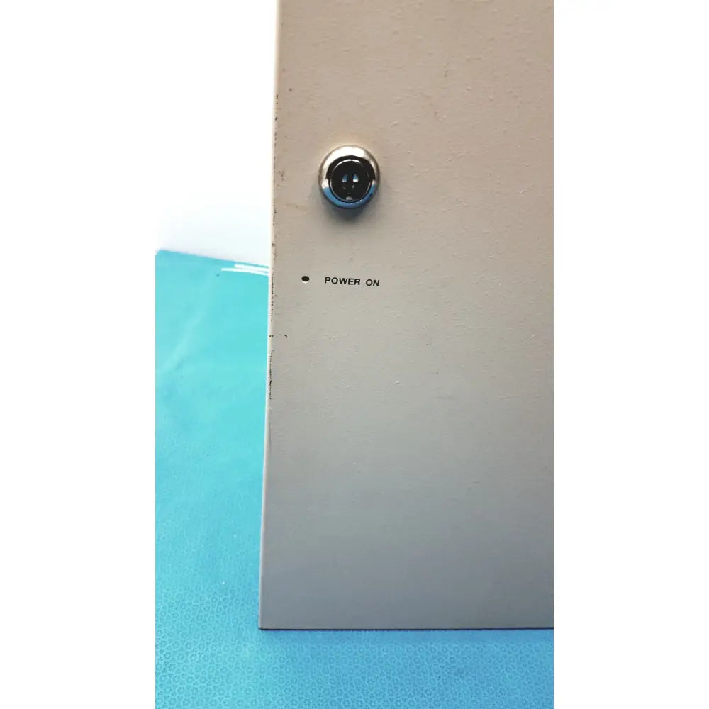 A circular chrome power indicator light on a beige metal panel of the cardkey s300-xl access control panel controller