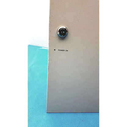 A circular chrome power indicator light on a beige metal panel of the cardkey s300-xl access control panel controller