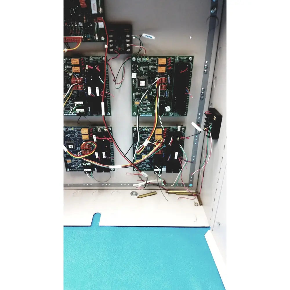 Green circuit boards with black components and multicolored wires in metal rack of s300-xl access control panel controller