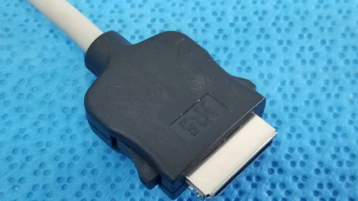 Black plastic dvi connector with silver pins attached to a white cable of carefusion coiled patient cable