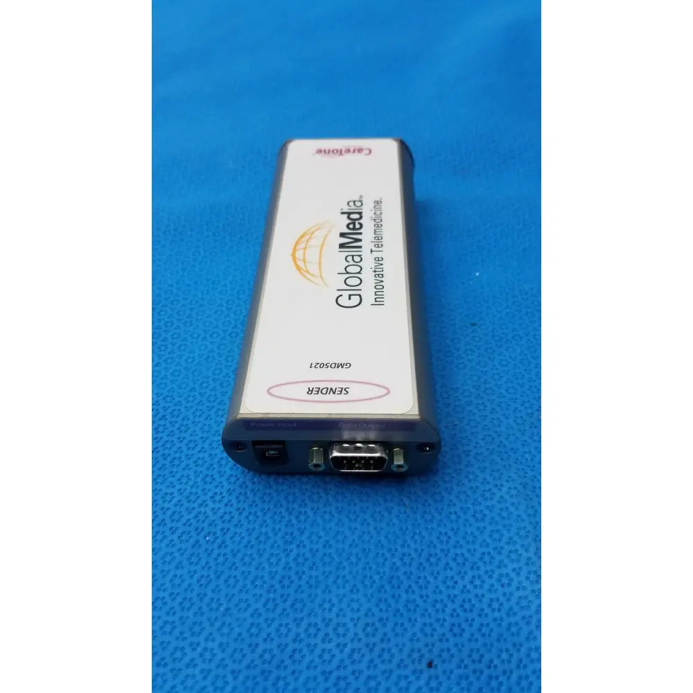 Back side of gray and white rectangular caretone global medical innovative telemedicine sender with db9 connector and globalmedia branding