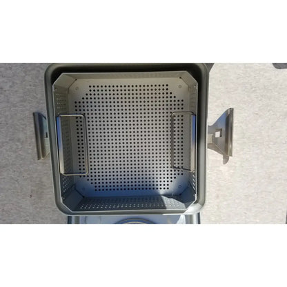 Gray perforated metal grill basket with two side handles for case medical half size sterilization use
