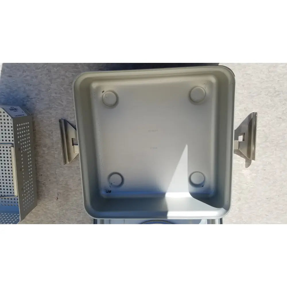 Silver metallic medical half size sterilization case with four circular feet and side handles for medical use