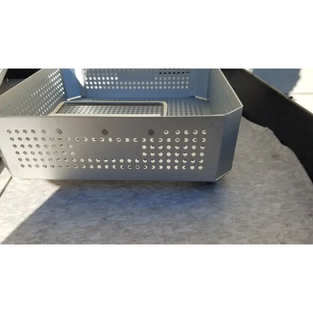 Silver perforated metal storage basket with a rectangular inner tray in case medical half size sterilization case and lid