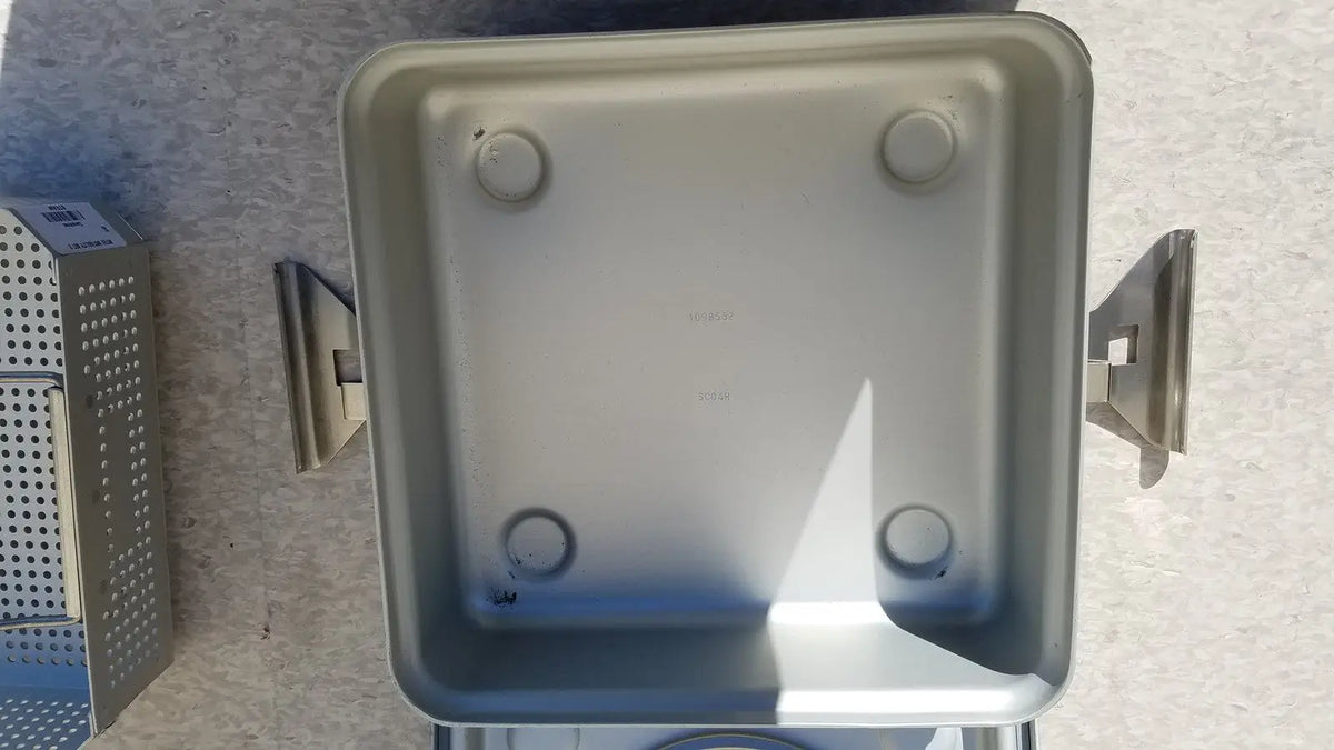 Silver metallic medical half size sterilization case with four circular feet and side handles for medical use