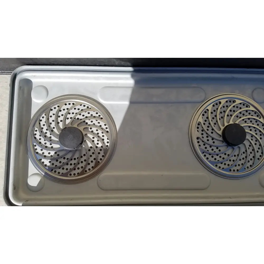 Two circular metallic burner grates with spiral pattern on stainless steel stovetop for case medical karl storz ksz 39402as container
