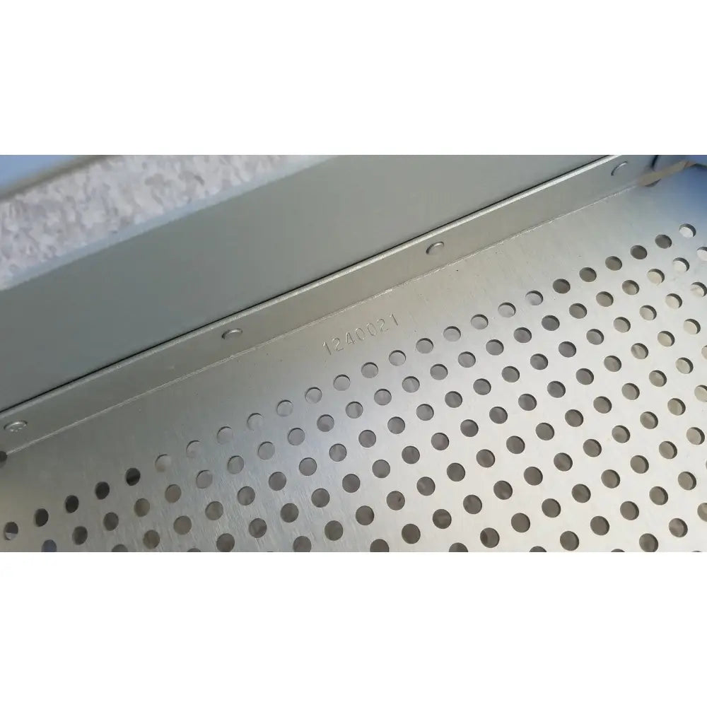 Silver case medical perforated aluminum sterilization insert tray with evenly spaced circular holes and stamped serial number