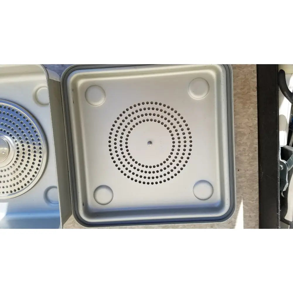 Silver metallic square sink drain cover with circular perforations and rounded indentations for case medical sterilization container half size lid