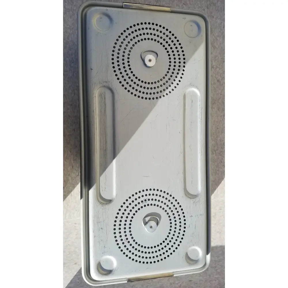 Silver metallic rectangular speaker grille with two circular perforations and integrated handles for case medical storage container