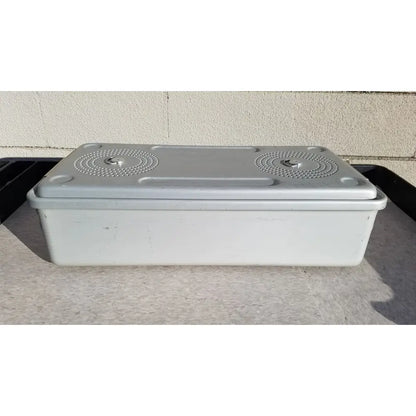 Gray plastic case medical storage container with matching lid, circular textured patterns, and small handles for sterilization