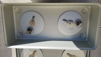 Gray plastic case medical storage container with two circular access panels, silver keyholes, and metallic latches