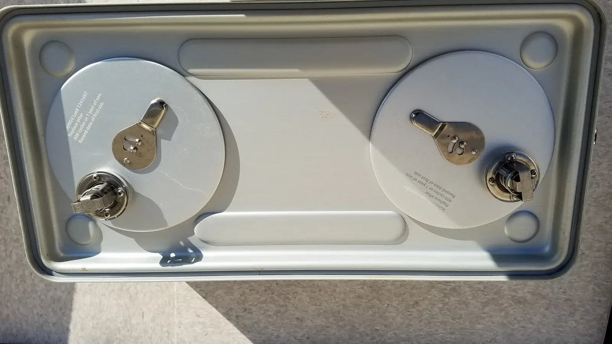 Silver-colored metal case medical storage tray with two cylindrical batteries secured by metallic terminals and keyholes