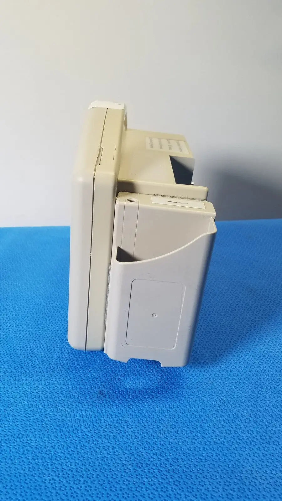 Beige plastic nintendo game boy advance sp handheld console shown with cartridge slot alongside masimo set spo2 blood pressure monitor
