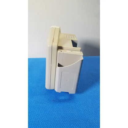 Beige plastic nintendo game boy advance sp handheld console shown with cartridge slot alongside masimo set spo2 blood pressure monitor
