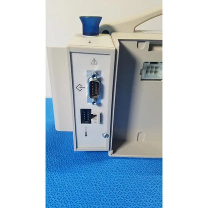 Back view of casmed 740 max nibp spo2 blood pressure patient monitor with blue button and rs-232 ethernet ports