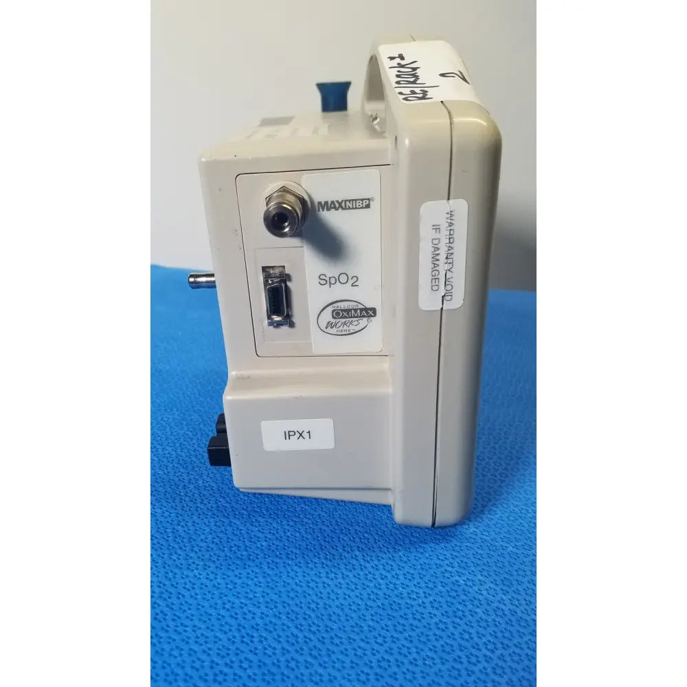 Beige casmed 740 max nibp vital signs monitor showing blue cap and labeled ports on the back side of the device