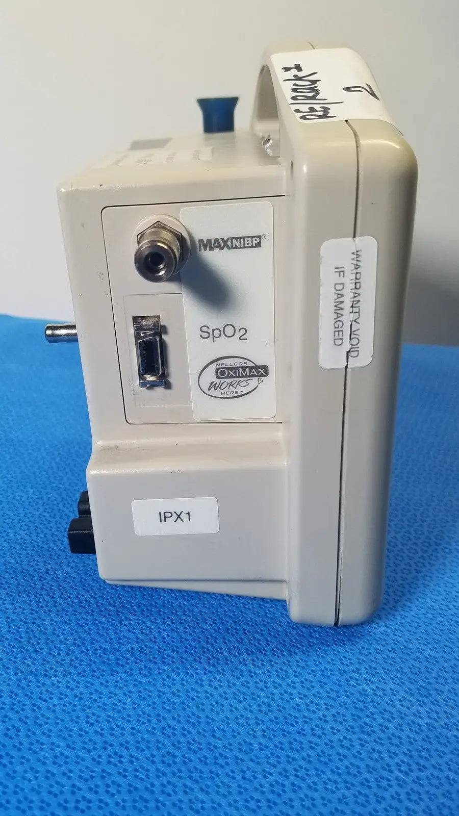 Beige casmed 740 max nibp vital signs monitor showing blue cap and labeled ports on the back side of the device