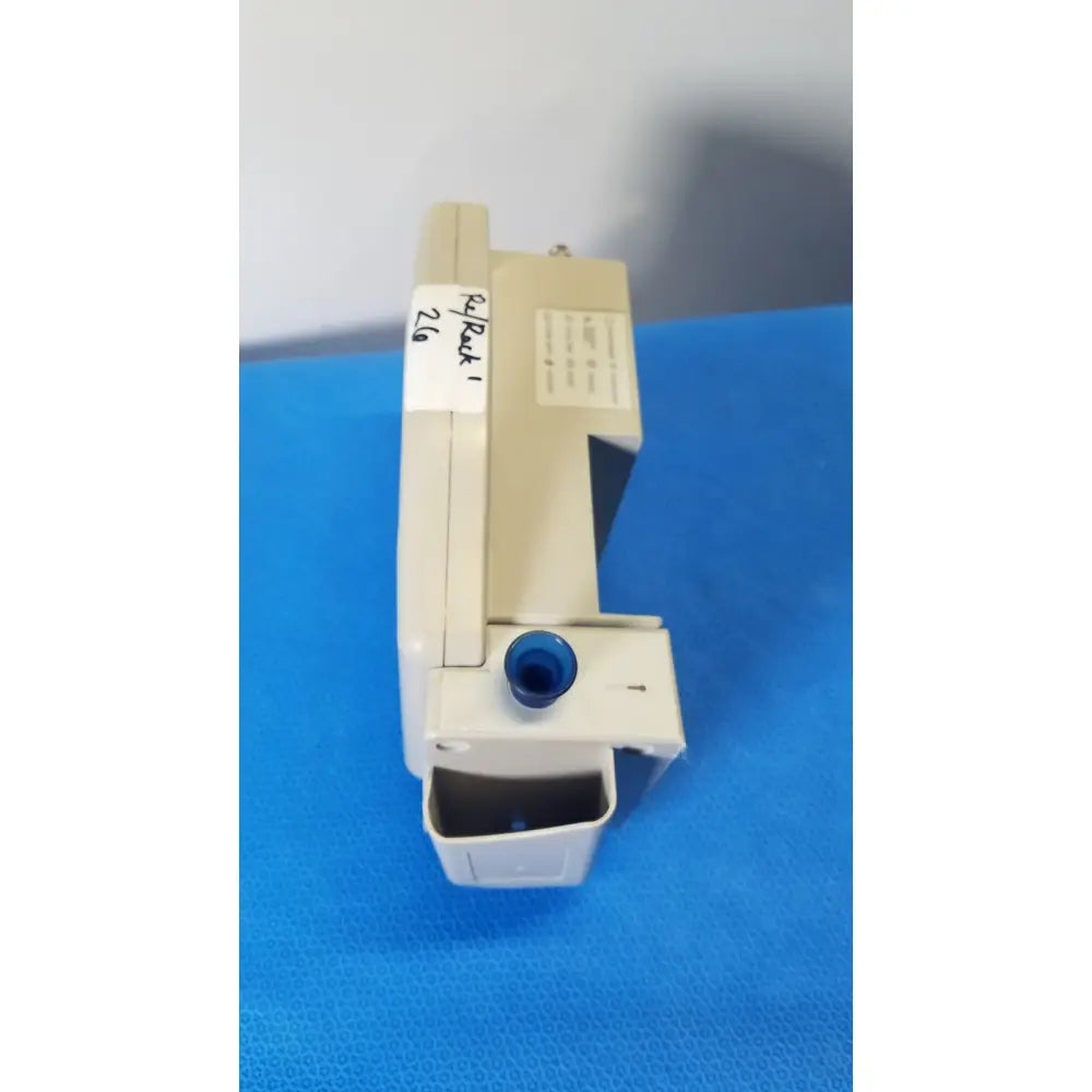 Beige plastic casing of casmed 740 patient monitor nibp with blue circular component and papback 1 label seen from back side