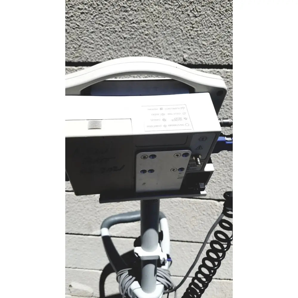 White casmed 740 vital signs monitor with sp02 finger probe and curved handle mounted on rolling stand for vital signs