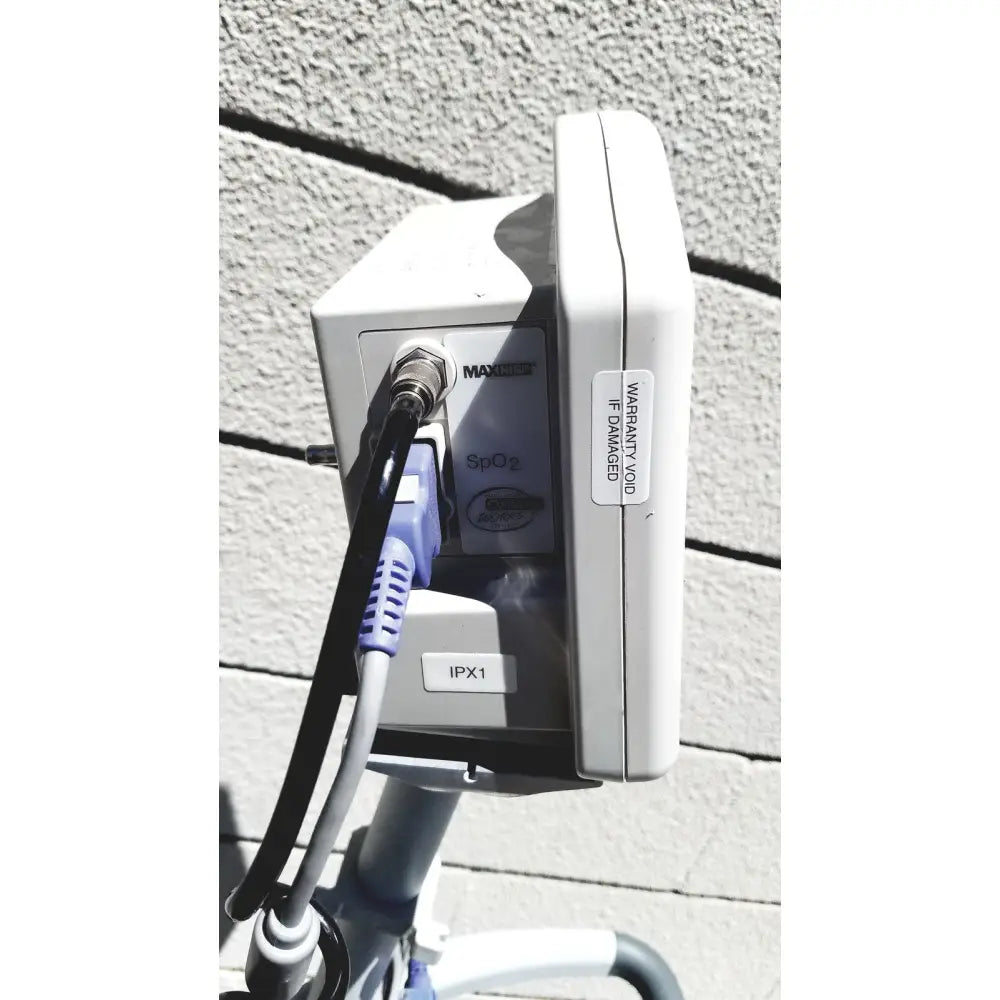 White plastic casmed 740 vital signs monitor with purple and black sp02 finger probe cable connected to port