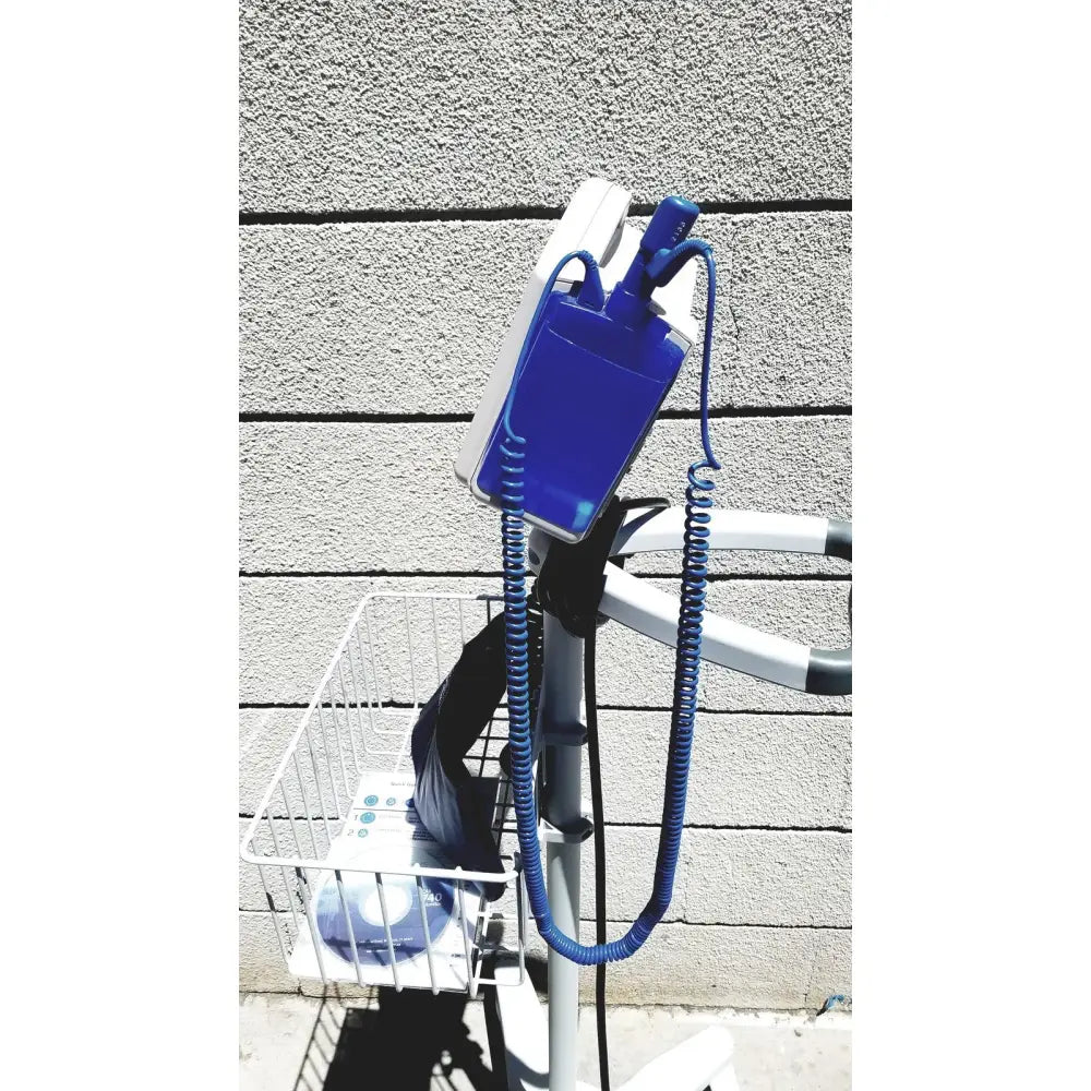 Blue and white casmed 740 vital signs monitor with coiled cord mounted on rolling stand for medical use
