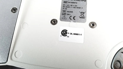 White plastic backplate of cellvizio foot pedal with silver screws and regulatory compliance labels visible